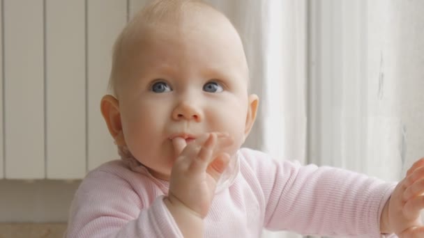 Primer plano del bebé sentado en el suelo cerca de la ventana — Vídeo de stock