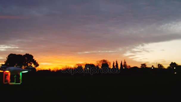 Quadrocopter met camera vliegen op avondrood backgroung — Stockvideo