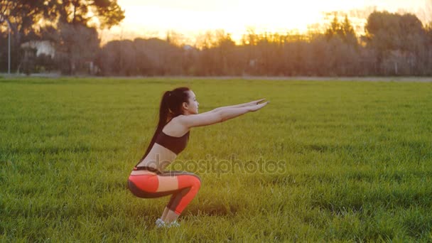 Vista laterale di giovane donna che fa squat all'aperto — Video Stock