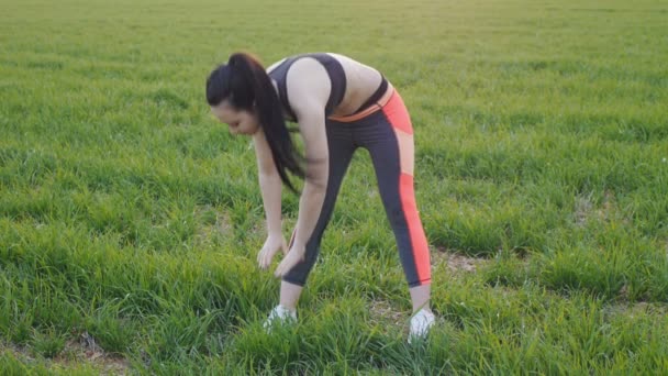 Flicka gör stående framåt bend utomhus — Stockvideo