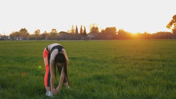 Chica estiramiento haciendo de pie hacia adelante curva al aire libre — Vídeos de Stock