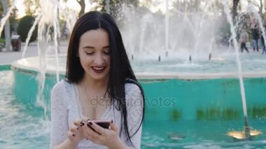 Smartphone kullanarak gülen kız portresi.