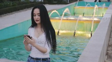 Smartphone kullanarak kız gülüyor.