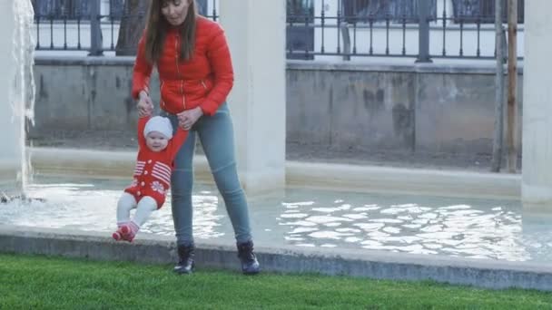 Sonriente madre sosteniendo al bebé en sus brazos, balanceándose y divirtiéndose — Vídeos de Stock