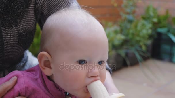 Baby eten van banaan uit handen van moeder — Stockvideo