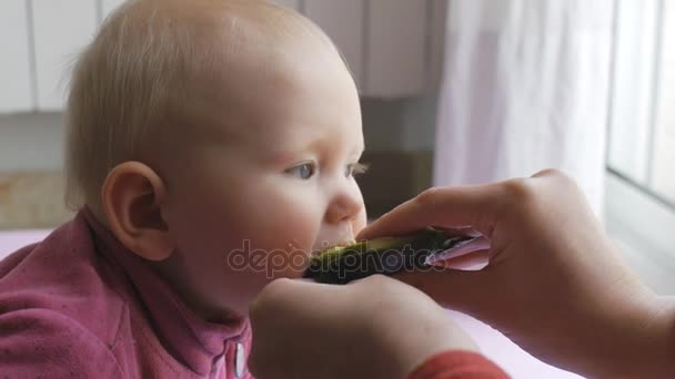 母親の手からアボカドを食べる赤ちゃん. — ストック動画