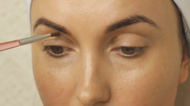 Genç kadın evde makyaj uygulamak.