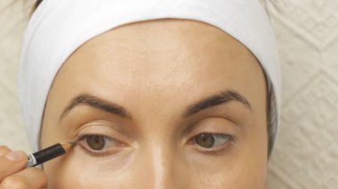 Genç kadın evde makyaj uygulamak.