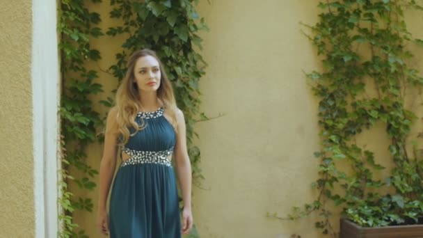 灰色のイブニング ドレスとハイヒールの若い女性はヨーロッパの中庭で散歩します。 — ストック動画