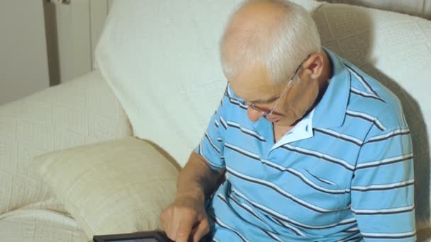 Homem idoso usa comprimido — Vídeo de Stock