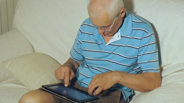 Пожилой человек пользуется планшетом — стоковое видео