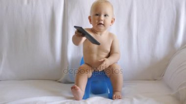 Bebek smartphone kullanarak lazımlık üzerinde oturur
