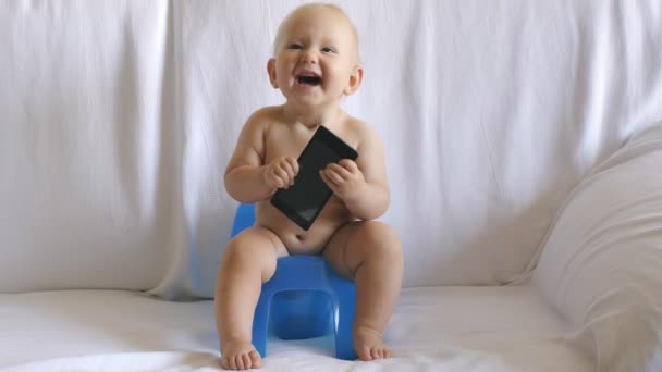 Baby sitzt mit Smartphone auf Töpfchen — Stockvideo