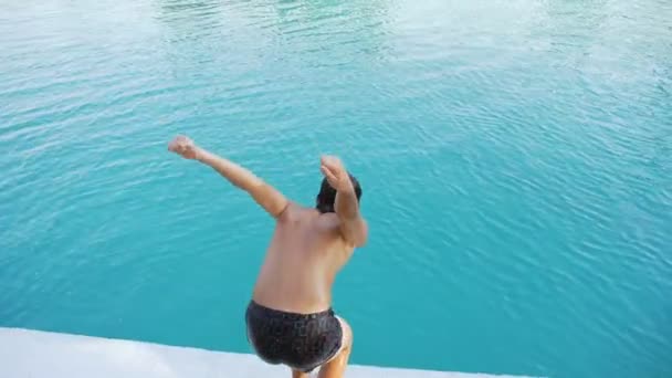 Adolescent saute dans la piscine — Video