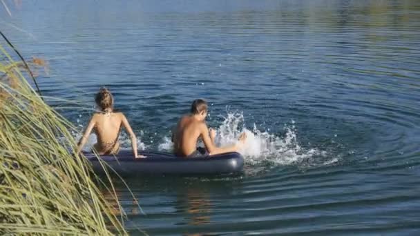 Garçon et fille flotte sur matelas gonflable — Video