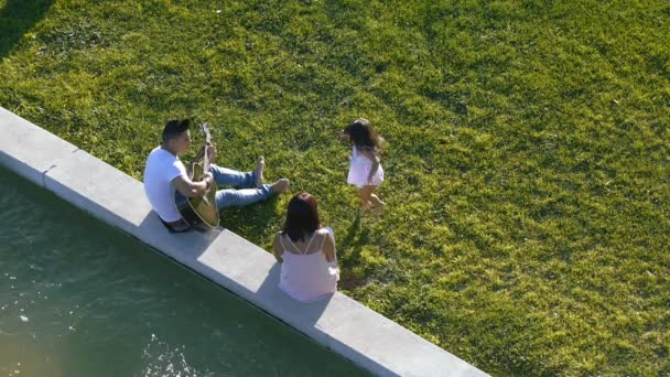 Família com criança caminha na grama verde — Vídeo de Stock