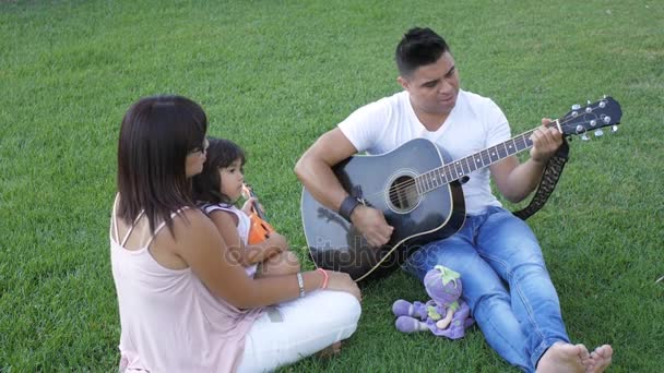 Rodina s dítětem chodí na zelené trávě — Stock video