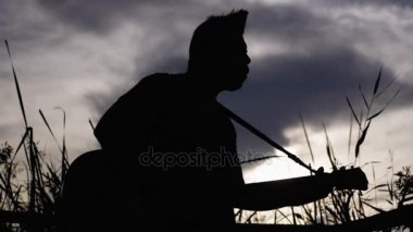 Gitar çalmak bir müzisyen silüeti