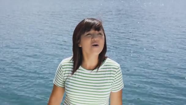 Female singer on blue lake background. — Stock Video