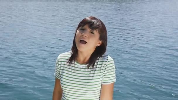 Τραγουδίστρια σε φόντο μπλε λίμνη. — Αρχείο Βίντεο