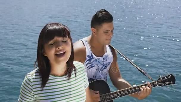 Женщина и мужчина поют песню с гитарой — стоковое видео
