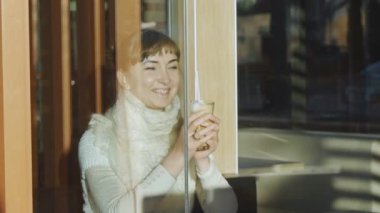 Genç kadın, kafede kahve içiyor. Dantel yün atkı kahve aroması gülümseyen ve latte bir pencere arkasında kamışla yudumlarken zevk ile Kafkas kadın portresi