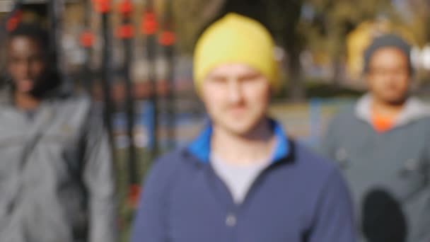 Entrenamiento callejero de equipo multirracial. Retrato del grupo deportivo de jóvenes hombres multiétnicos liderados por un entrenador de pie en el gimnasio al aire libre — Vídeos de Stock