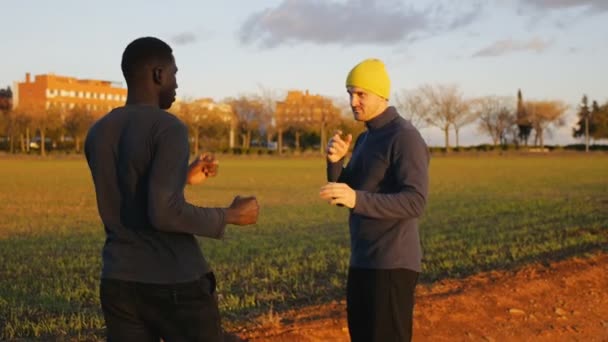 Boxing workout with trainer outdoors. Fighters sparring in a field at sunset time. The coach shows defending a punch technique. — Stock Video