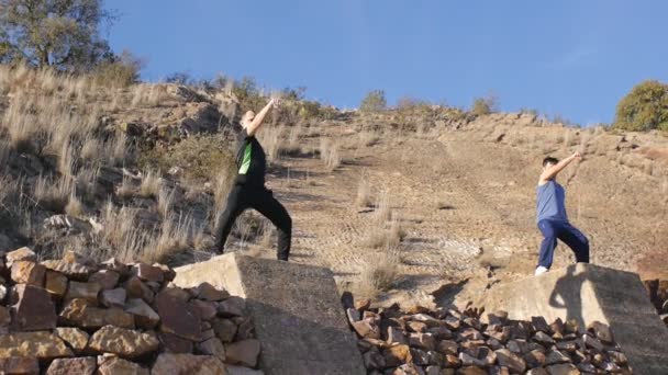 Allenamento con personal trainer all'aperto. Due fitness training uomo per colpire in piedi su grandi blocchi di cemento come parte di una routine di allenamento . — Video Stock