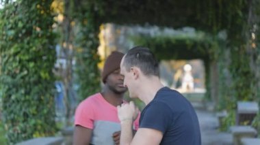 Kendini savunma egzersiz eğitmeni açık havada. Genç adam kendini savunma teknikleri kişisel antrenör Park ile pratik örme şapka siyah. Aldatıcı kombinasyonu.