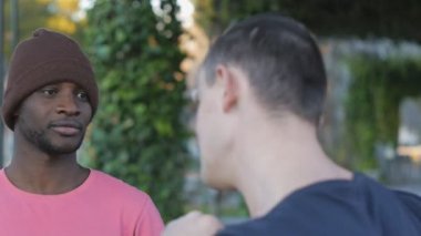 Kendini savunma egzersiz eğitmeni açık havada. Yakın çekim siyah gencin kendini savunma teknikleri kişisel antrenör Park ile pratik örgü şapkalı. Savunmak ve delme birleşimi.