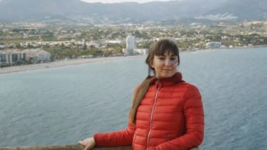 Genç deniz arka plan üzerinde kadın. Rüzgar ayakta bahar plaj arka plan üzerinde yükseltilmiş gezi platformunda saç çırpınan ile çekici Kafkas kadın portresi.
