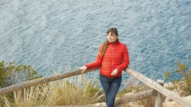 Genç deniz arka plan üzerinde kadın. Deniz dalgaları arka plan üzerinde olan gözlem güverte üzerinde Rüzgar duran içinde çırpınan saç çekici beyaz kadın yüksek açılı görünüş.