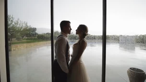Υπέροχο ζευγάρι κοντά στο παράθυρο με σταγόνες βροχής. — Αρχείο Βίντεο