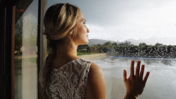 Lovely couple near window with raindrops. — Stock Video