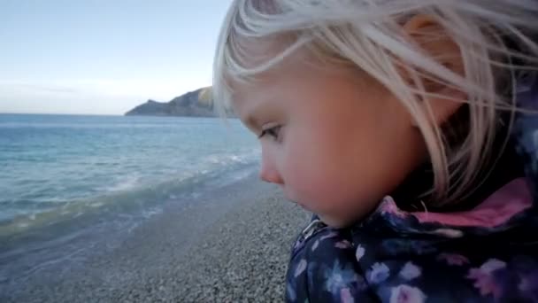 Kleines Mädchen spielt am Kieselstrand. — Stockvideo