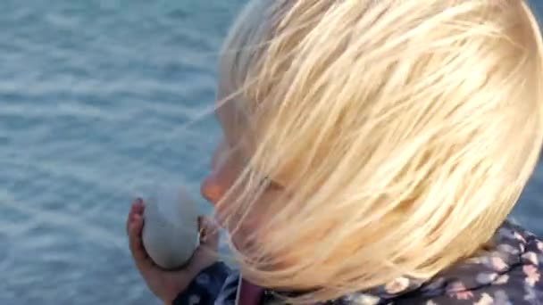 Malá dívka hraje na oblázkové pláži. — Stock video