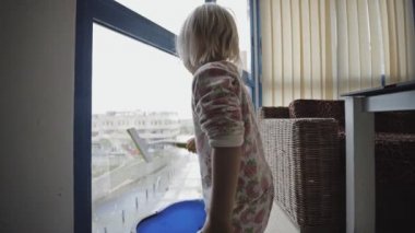 Çocuk pencere temizleme oyunu oynuyor.