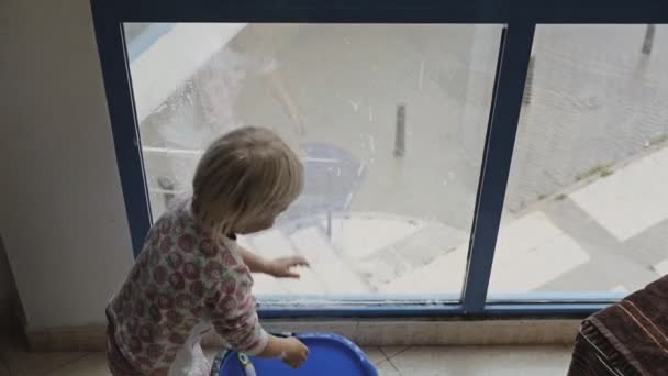 Niño juega ventana de limpieza . — Vídeos de Stock