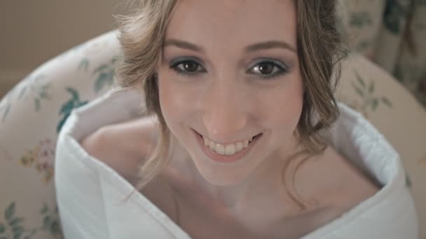 Donna sorridente avvolta in una coperta bianca . — Video Stock