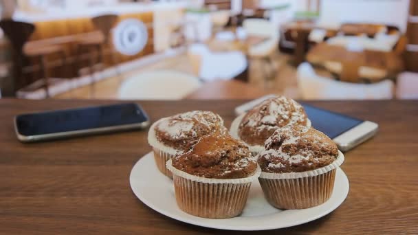 Hände nehmen vier Muffins auf einem weißen Teller — Stockvideo