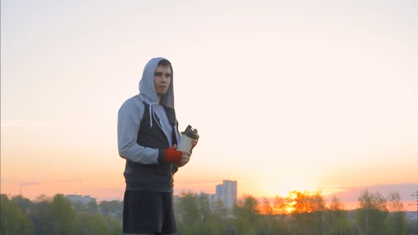 Boxeador bebiendo batido de proteínas al aire libre — Vídeo de stock