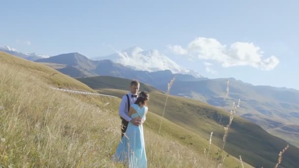 Couple de jeunes câlins sur fond de montagnes — Video