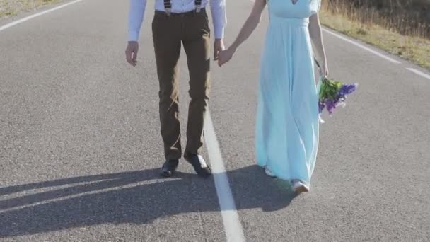 Elegante giovane coppia che cammina per mano sulla strada tra le montagne — Video Stock