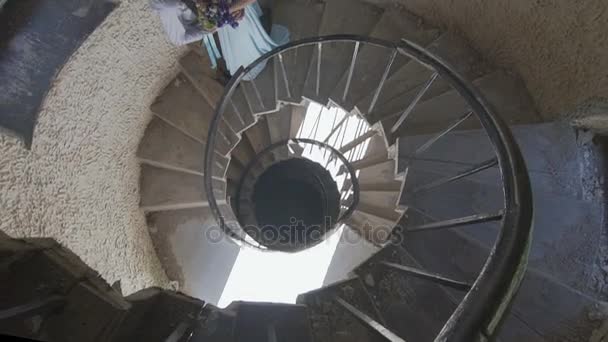 Стильная пара позирует на спиральной лестнице — стоковое видео