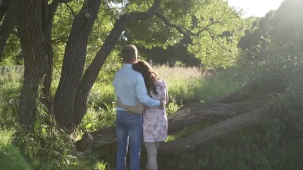 Chica y chico al atardecer en el bosque — Vídeos de Stock