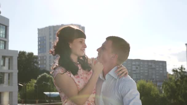 Το κορίτσι και ο τύπος σε ένα φόντο πόλη σε μια ηλιόλουστη ημέρα — Αρχείο Βίντεο