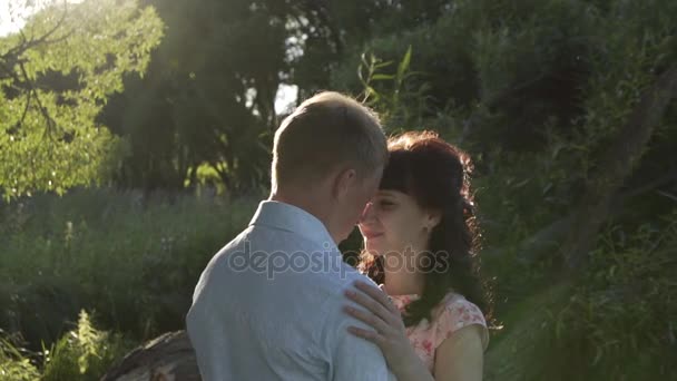Flicka och hennes pojkvän i den nedgående solen i skogen långsamma mo — Stockvideo