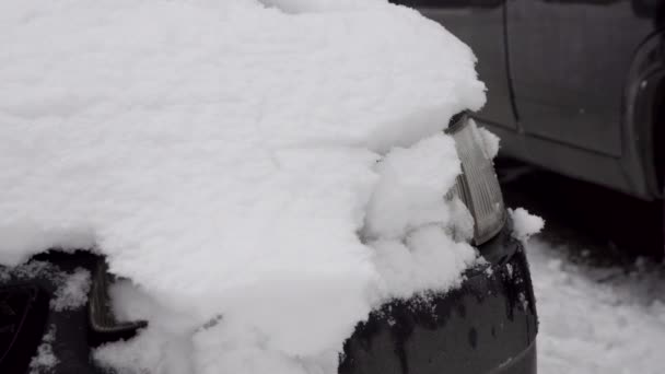 Car headlamp in winter during a snowfall — Stock Video