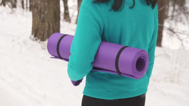 Дівчина з килимком для йоги на зиму повільно мо — стокове відео